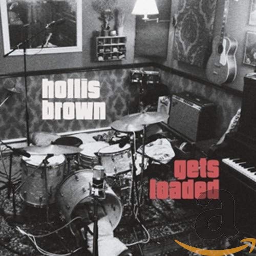 "Black and white image of a drum set in a room with 'hollis brown gets loaded' text."