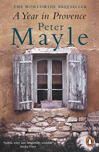 The image shows a book cover with a worn, rustic window. "Paperback book cover with old window and shutters on a stone wall."