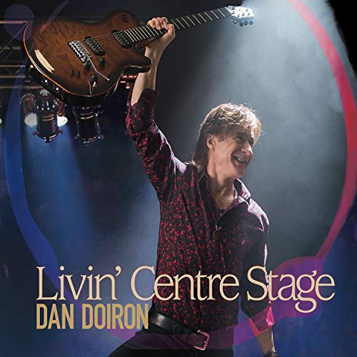 Man holding guitar aloft on stage, surrounded by spotlights, with text "Livin' Centre Stage Dan Doiron".