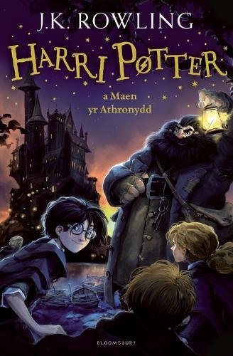 The image depicts the cover of a book titled "Harry Potter and the Philosopher's Stone" in Welsh. The alt text is: "Book cover featuring Harry Potter and friends with Hagrid at night."