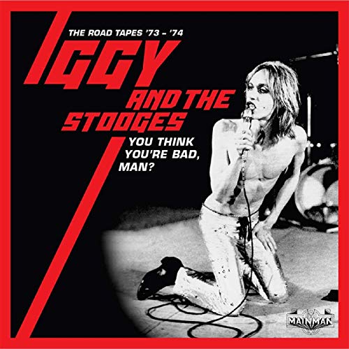 Iggy Pop kneeling on stage, holding a microphone, on a black album cover with red border.
