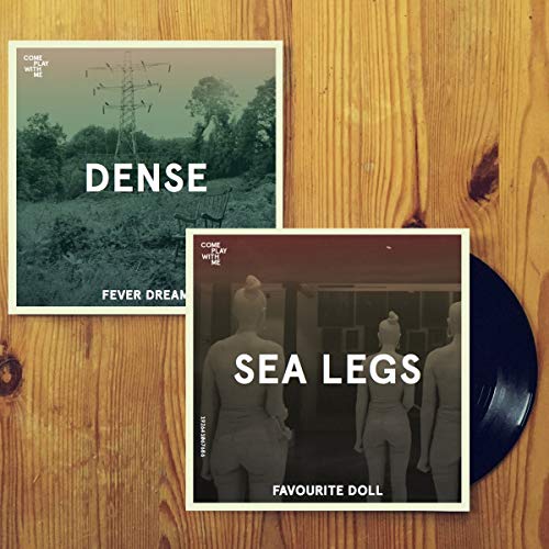 A vinyl record with two album covers on a wooden surface.