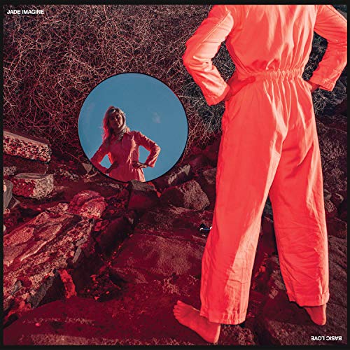 The image is a vinyl record cover featuring a woman in a pink jumpsuit. For accessibility purposes, a concise alt text could be: "Album cover with a woman in a pink jumpsuit outdoors."