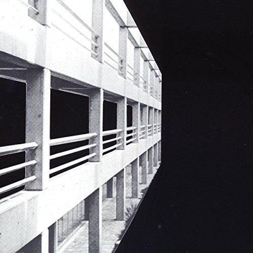 The alt text for the image is: "Black and white vinyl record sleeve featuring a building facade."