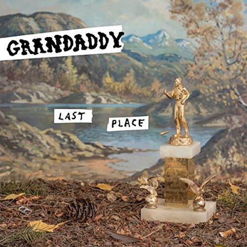 "Vinyl album cover with a gold trophy and a scenic landscape background."
