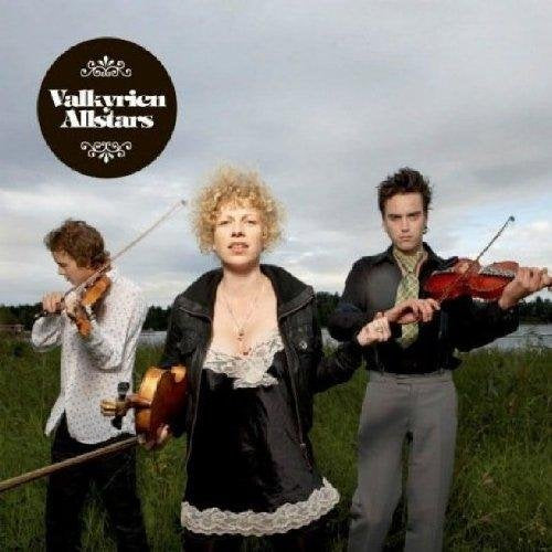 "Album cover with three musicians, two playing violins, standing in a grassy field."