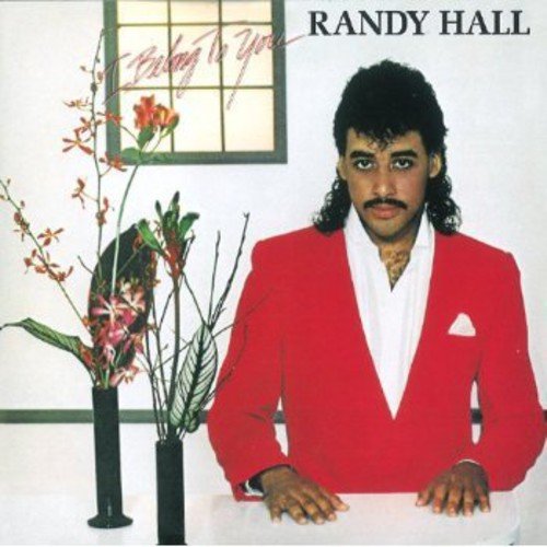 Album cover with Randy Hall in red suit, leaning on a table with flowers.