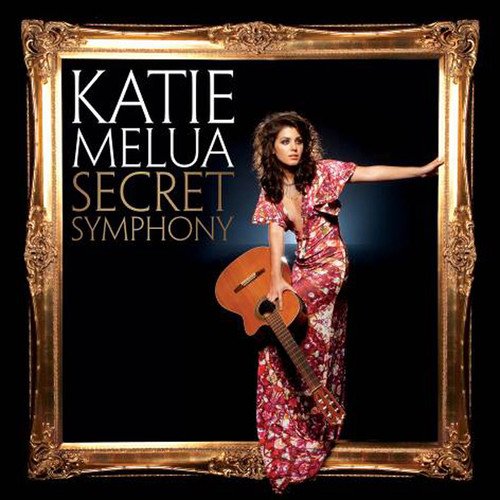 Katie Melua holding a guitar, standing in an ornate gold picture frame.