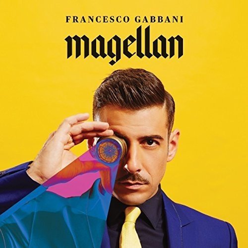 Man in blue suit and yellow tie holding CD, yellow background, "Francesco Gabbani Magellan" text.