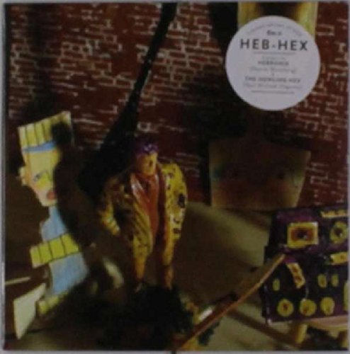 Vinyl album cover with mannequin and totem pole against a brick wall.