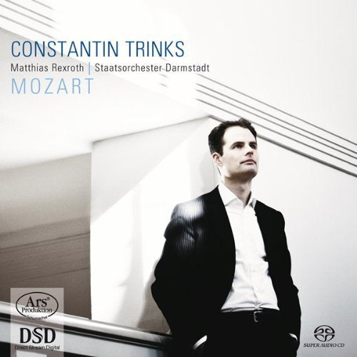 A man in a suit stands on a staircase, Mozart CD cover.