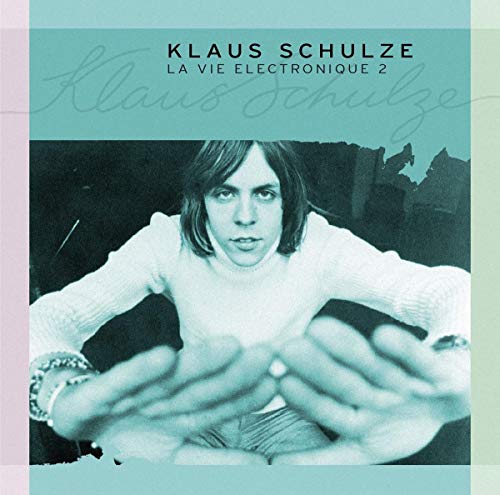 "Klaus Schulze album cover featuring a man with outstretched hands, teal-toned image."