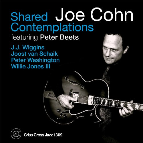 "Album cover with a man playing guitar, black background, blue and white text."