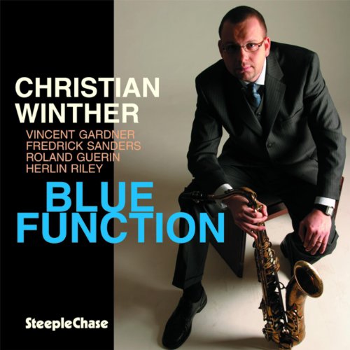Man in a suit kneeling, holding a saxophone, on a music album cover.