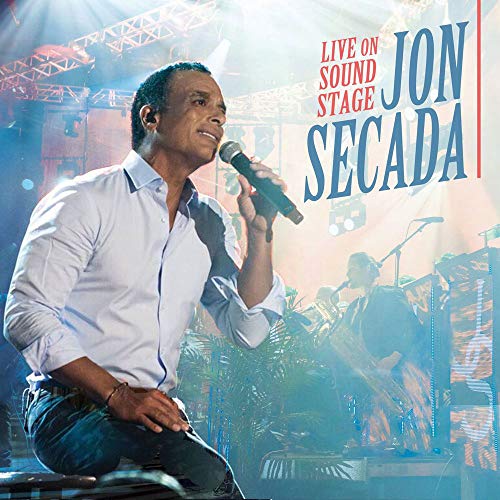 DVD cover of Jon Secada singing into a microphone on a lit stage.