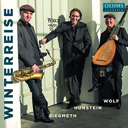 "CD cover featuring three men in suits holding musical instruments, standing by a door."