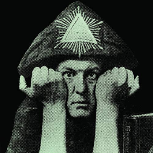 "Black-and-white image of Aleister Crowley wearing a hat with a triangle symbol."