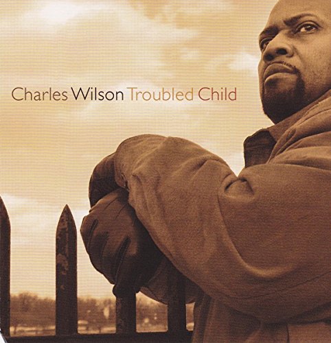 Album cover with man leaning on a fence, sepia-toned, with artist and title text.