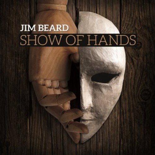 "Album cover with a wooden hand holding a white mask against a dark wood background."