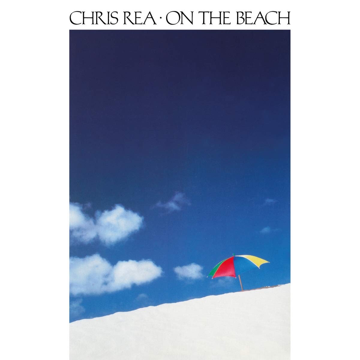 "Album cover with a multicolored beach umbrella on white sand against a blue sky."