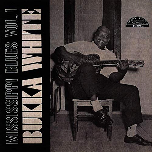 "CD cover featuring a man sitting on a chair, playing a guitar."