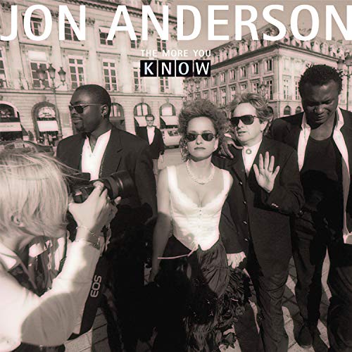 "Black and white album cover with Jon Anderson and entourage being photographed."