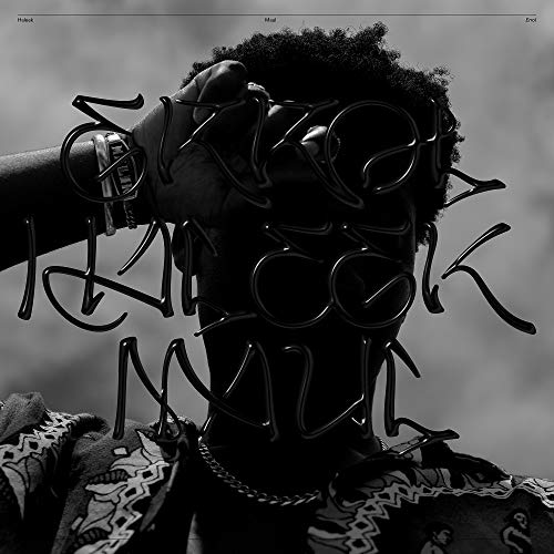 Black-and-white image of a person wearing a metal face cage, obscuring their facial features.