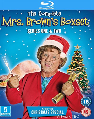 "Mrs. Brown in a red jacket and Santa hat, holding kitchen utensils, beside a Christmas tree."