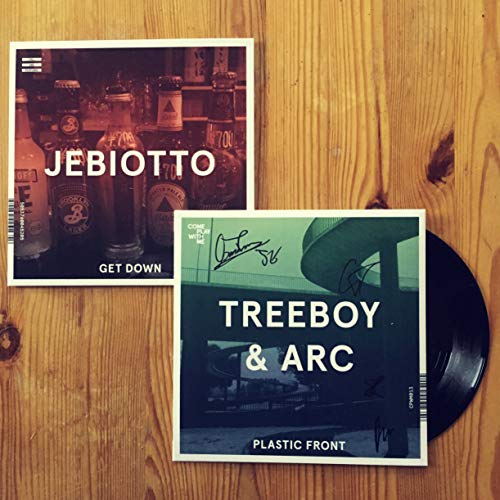"Two vinyl records on a wooden surface, with album covers featuring text and images."