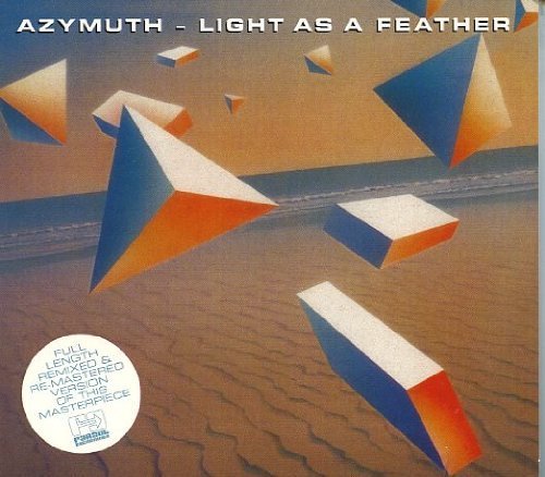 "Album cover featuring 3D geometric shapes on a sandy beach with ocean in background."