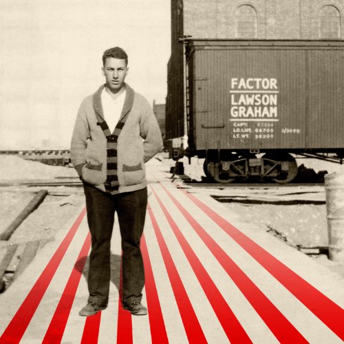 "Man stands on red and white striped ground with train car behind him."
