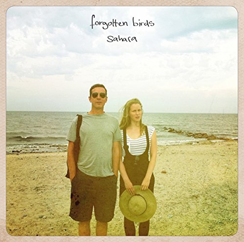 "Album cover with man and woman on a beach, 'Forgotten Birds Sahara' text."