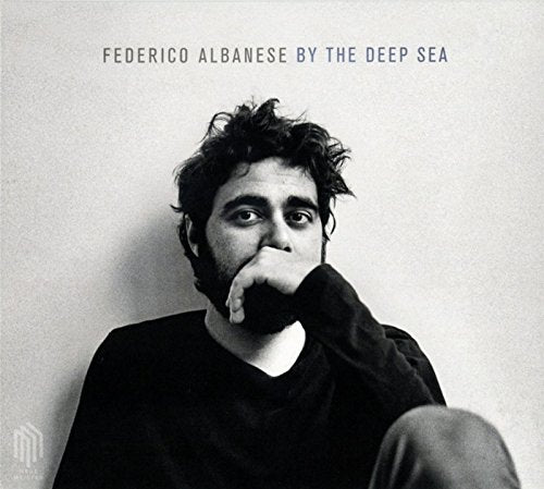 Black and white album cover featuring a man resting his chin on his hand.