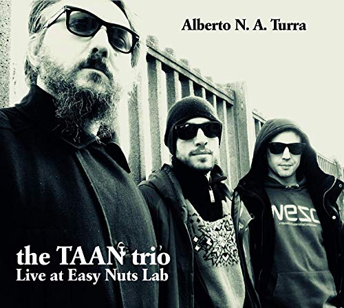 Black and white album cover featuring three men wearing sunglasses and dark clothing.