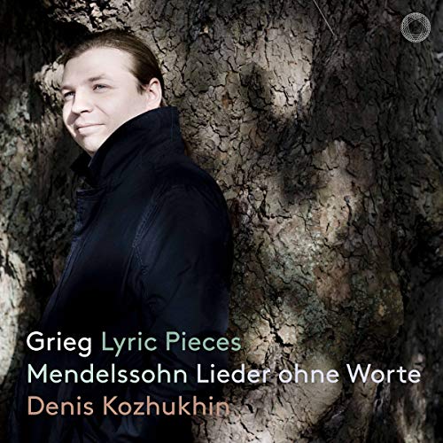 Man in dark coat standing beside a tree trunk, with text overlay on the image.