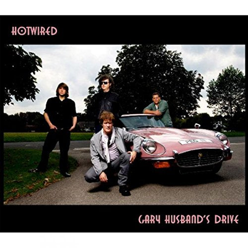 "Album cover featuring four men posing around a pink convertible car."