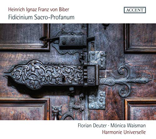 Ornate, dark metal door hardware on a wooden door, with text and logo above and below.