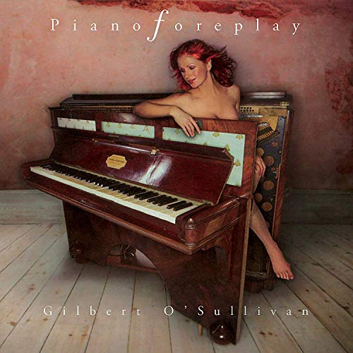 "Album cover with a topless woman leaning on an open piano, wooden floor background."
