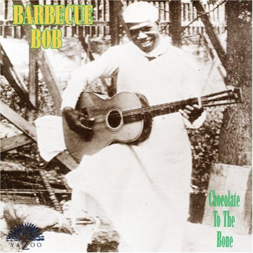 "Album cover with black-and-white photo of man holding guitar, wearing white robe and cap."