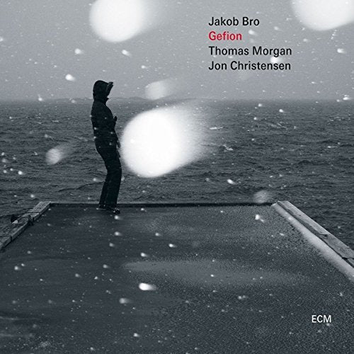 "CD cover featuring a person standing on a dock in a snowy landscape."