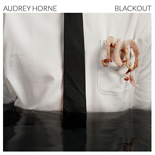 "Album cover with a white shirt and tie, octopus tentacles in pocket, black background."