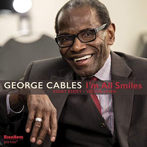 "Album cover featuring George Cables smiling, wearing glasses, suit, and red tie."