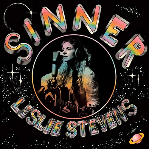 Album cover with a woman holding a guitar and microphone, surrounded by rainbow text.