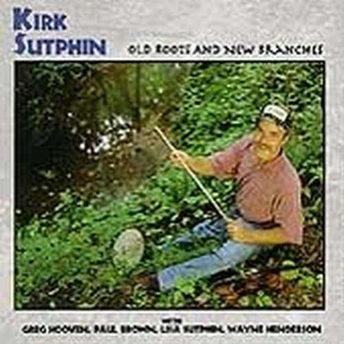 "Album cover featuring a man kneeling in greenery, holding a stick."