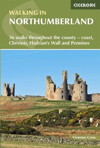 "Book cover showing two hikers and dog on a stone wall with a lake."