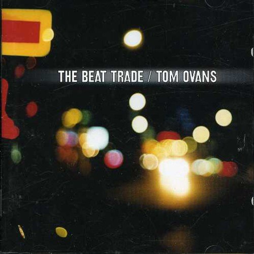 "Album cover with blurry city lights at night, 'The Beat Trade / Tom Ovans' text."