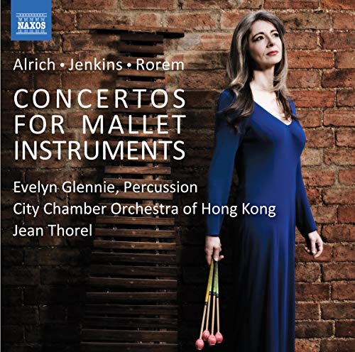 "CD cover featuring a woman in blue dress holding mallets against a brick wall."