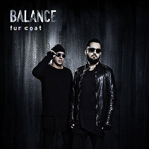"Album cover featuring two men in dark clothing and sunglasses against a dark background."