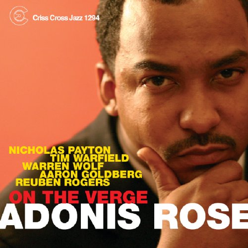 "Album cover with a man's face and red background, featuring artist and title text."