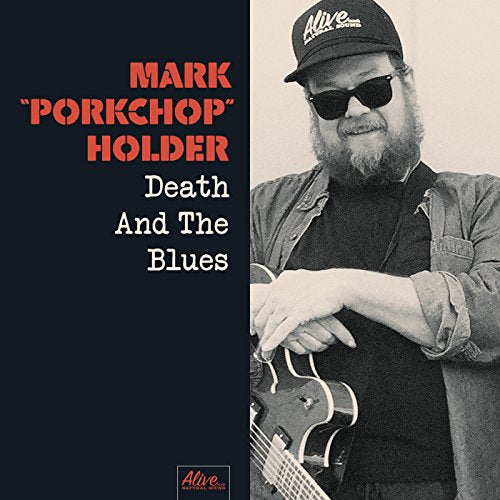 "Album cover with a man holding a guitar, wearing sunglasses and a cap."